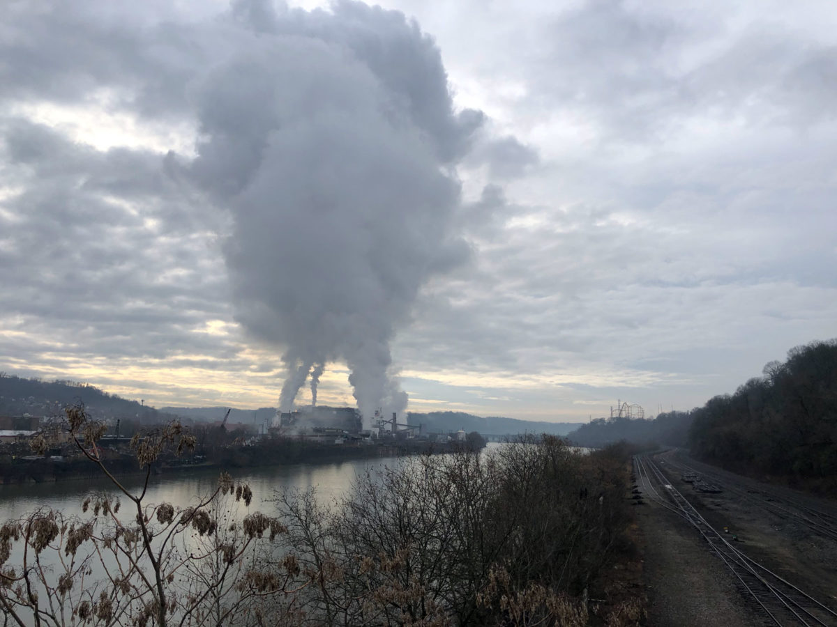 A factory emitting plumes of smoke up into the clouds