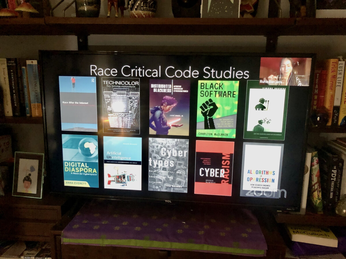 Picture of a TV that has a slide reading "Race Critical Code Studies" and 10 different book covers